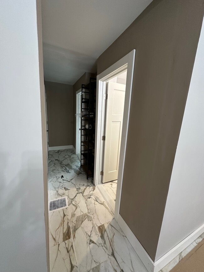 Hallway to bathrooms with storage. - 8215 Lake Pleasant Rd