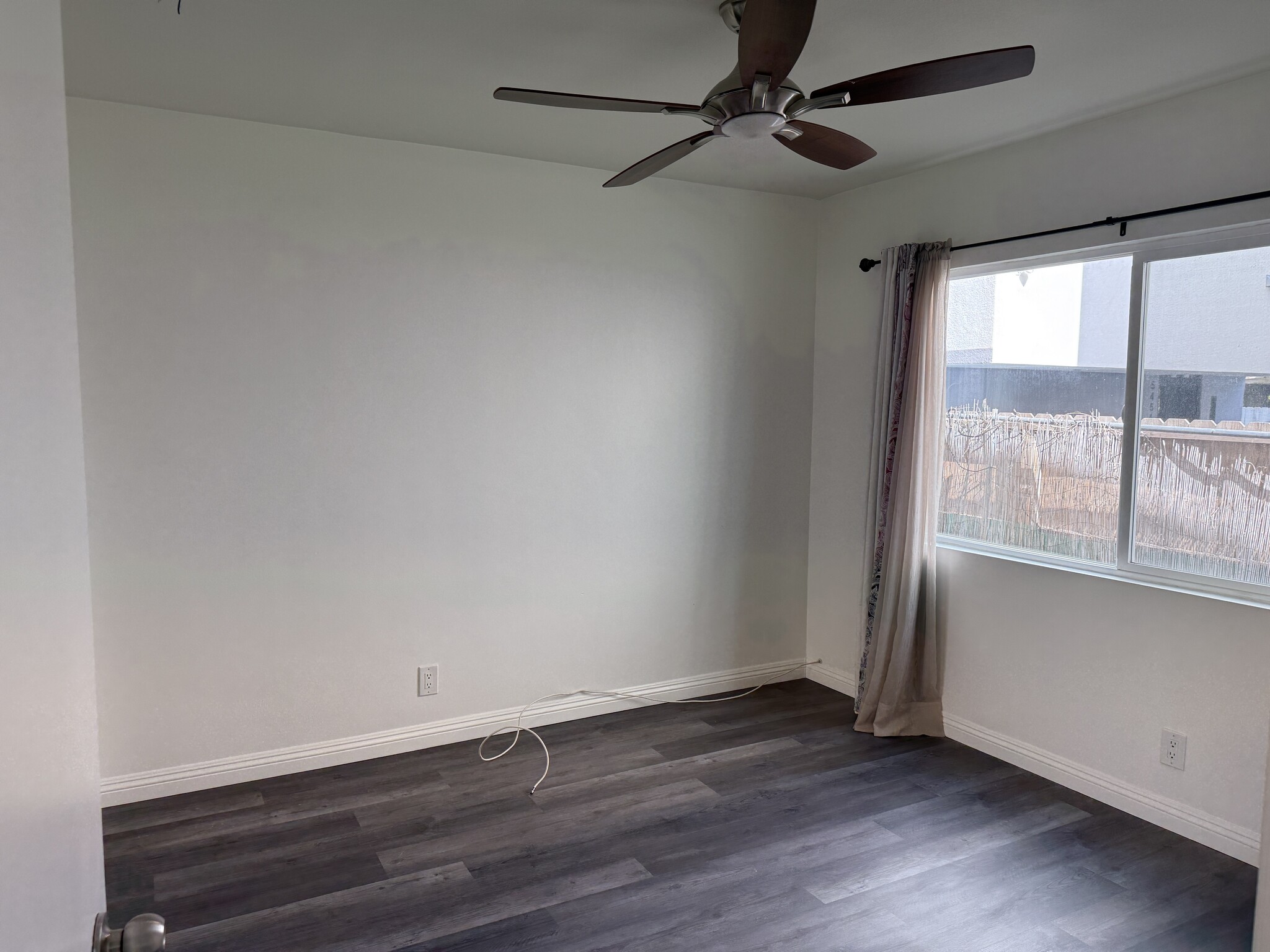 Bedroom with new floor and paint, large window, and ceiling fan - 5462 Barton Ave