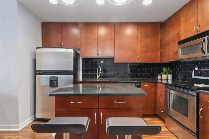 Kitchen with dark cherry cabinets, stainless steel appliances and movable island. - 860 Peachtree St NE