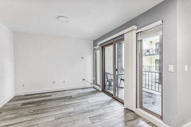 Sunlit room with a large window and wood-like flooring - 2520 College Avenue