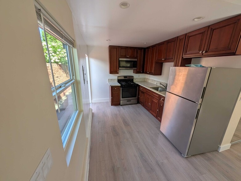 Full kitchen with stainless appliances and granite countertops - 6534 Peterson Ave