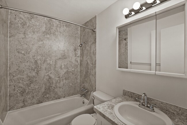 Modern bathroom with elegant finishes and practical storage. - Rainier Gardens Aparments