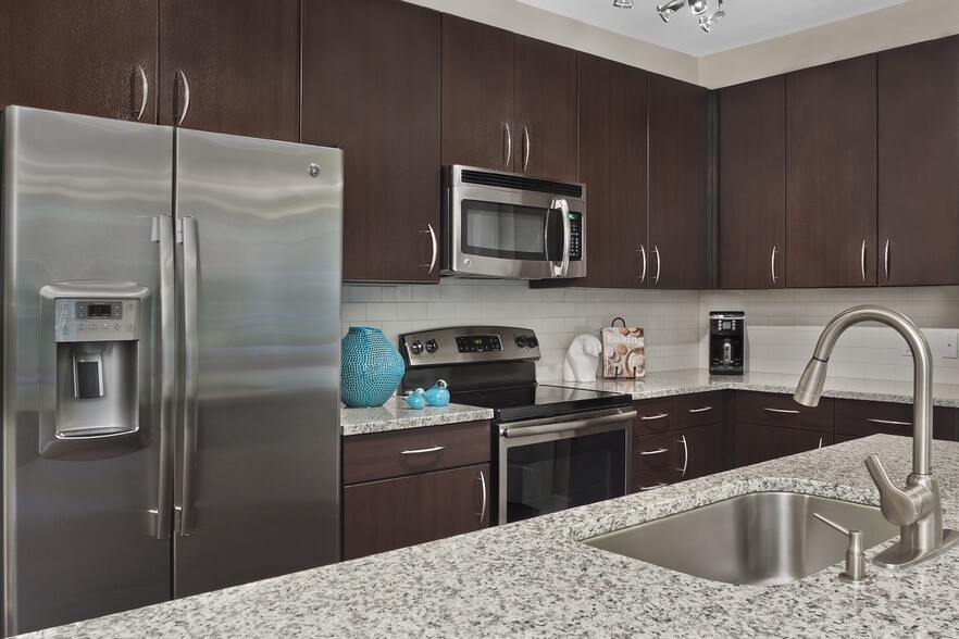 Kitchens with granite counters, subway tile backsplash and side-by-side stainless steel refrigerator with exterior ice/water dispenser - Marshall Park Apartments + Townhomes