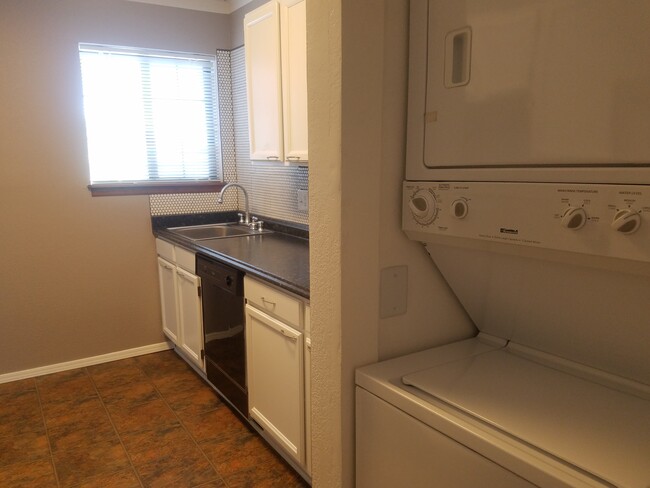 Stacked washer and dryer in kitchen. - 945 Tampico Court