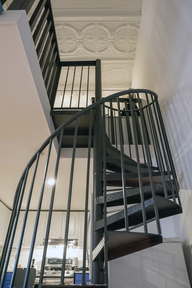 Industrial spiral staircase leads to walk in closet and bedroom - 25 N Broadway
