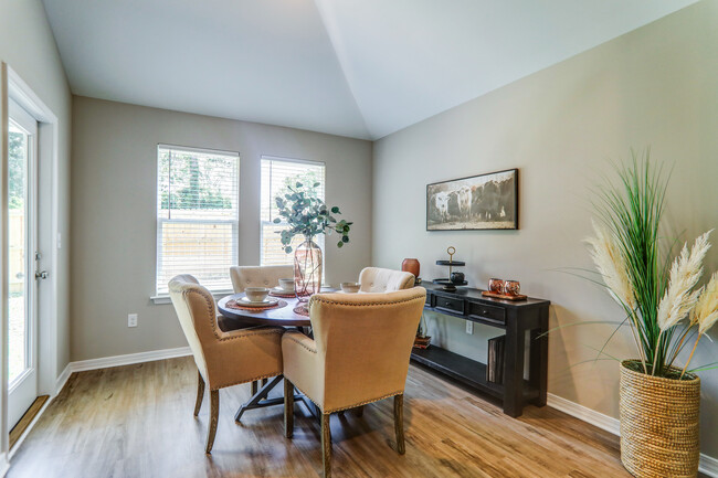 a dining room with a table and chairs and a fireplace - Cottages at Parkstone