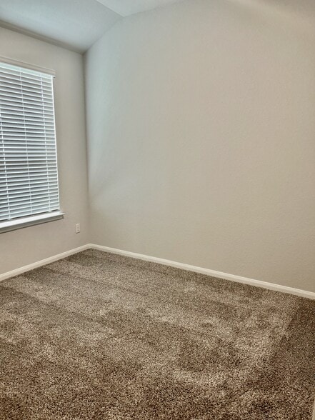 The spacious secondary bedroom features carpet and wooden blinds. - 509 Turtle Dove Dr