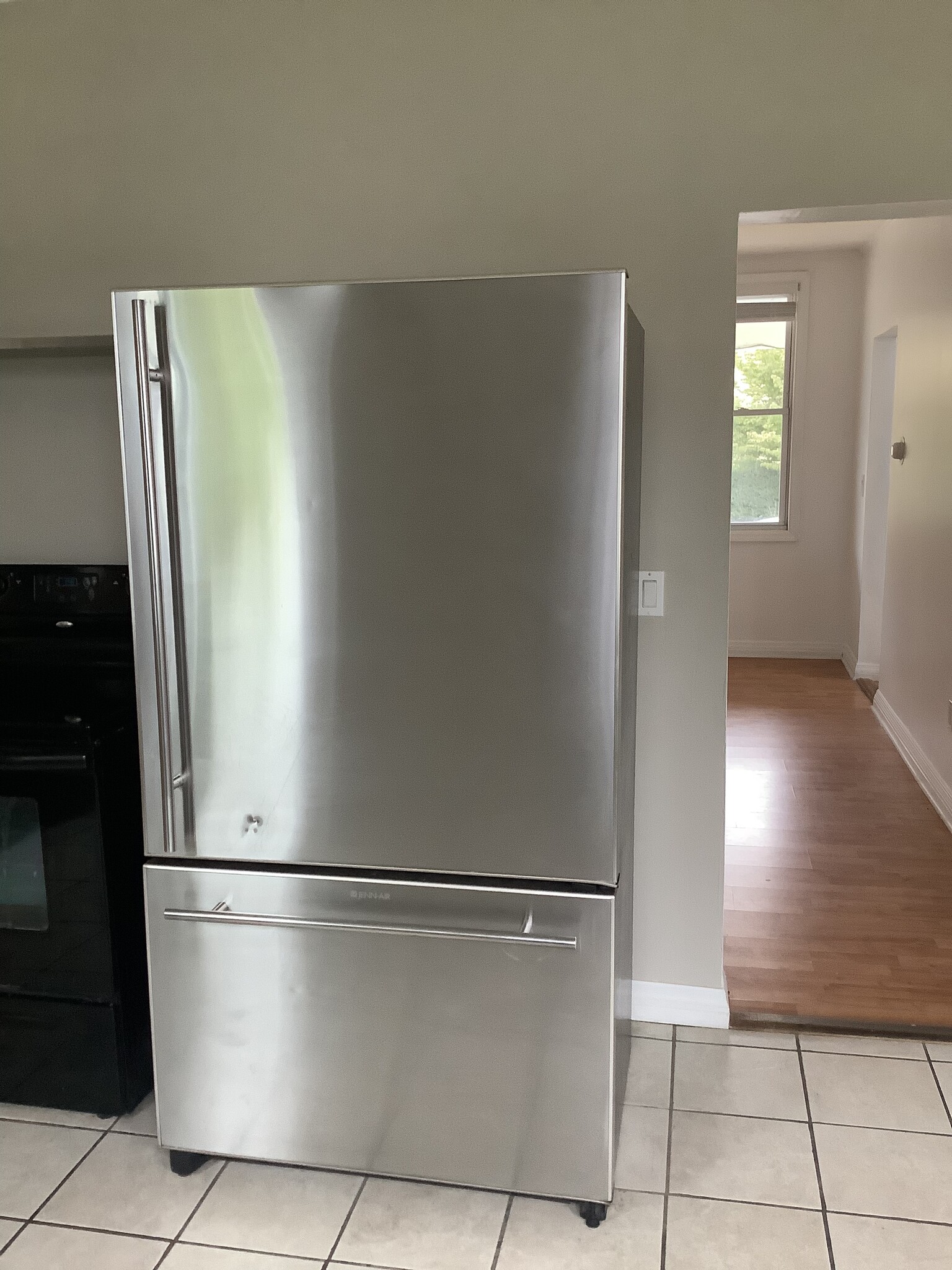 Jenn-Air stainless steel refrigerator with view of dining room beyond. - 11 Jay St