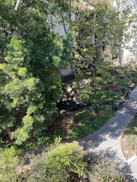 Top-floor balcony overlooking mature trees and landscaped grounds - 8305 Summertime Ln