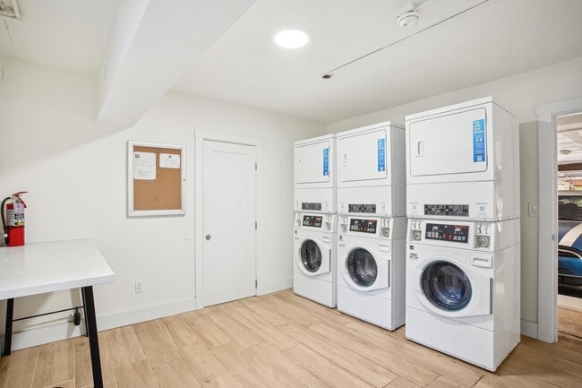 Laundry room with washing machines neatly arranged on a wooden floor - 2363 Le Conte Avenue