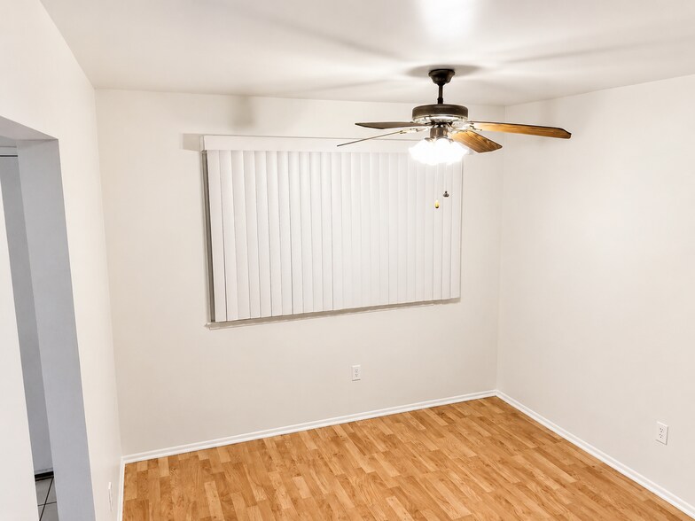 Bright dining area with wood-look flooring, ceiling fan, window coverings, and convenient access to - 339 E Taft Ave