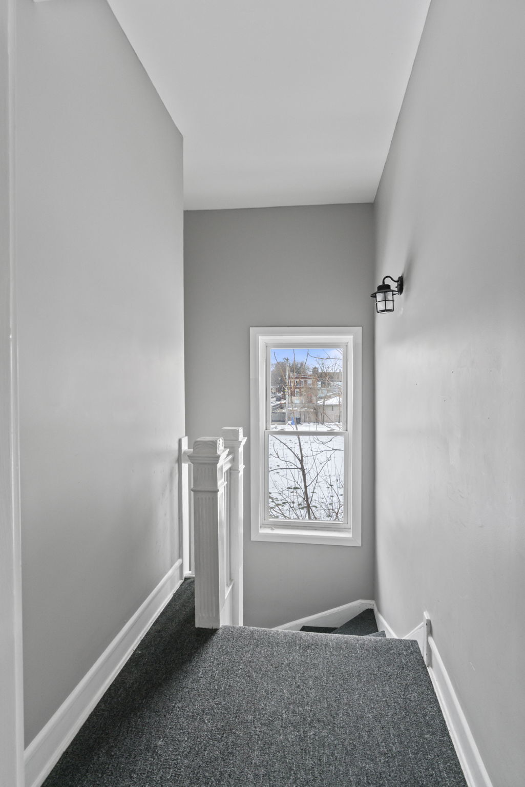 Carpeted stair landing with a large window that brings in plenty of natural light. - 7028 S Peoria St