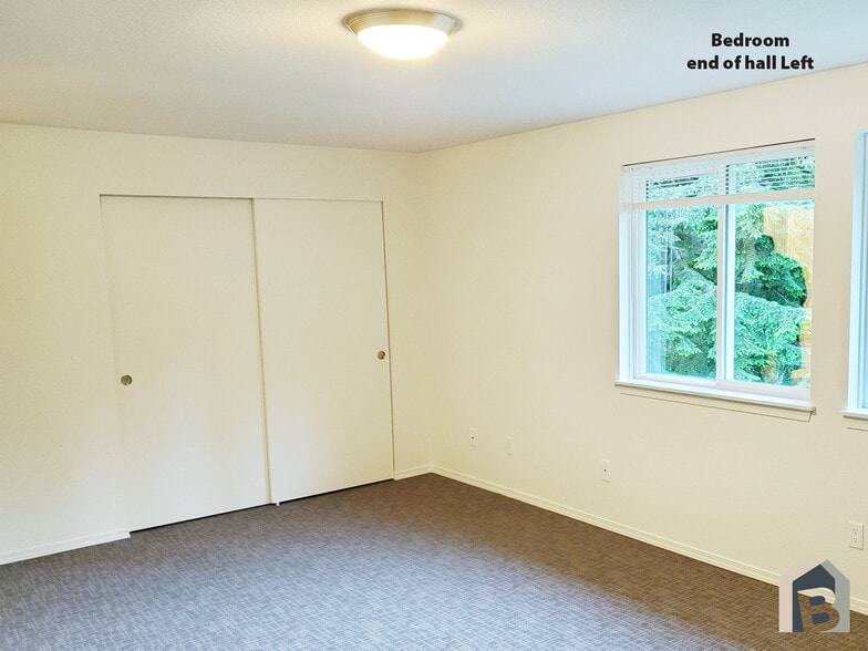 2nd floor large bedroom with view of lawn and mature evergreen trees and double closet - 20981 Port Gamble Rd NE