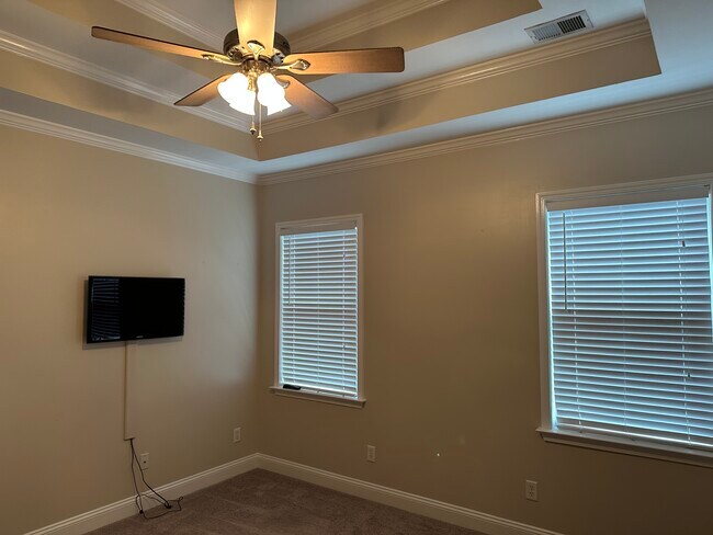 Primary bedroom with tray ceiling and mounted TV - 3406 Margrave Rd