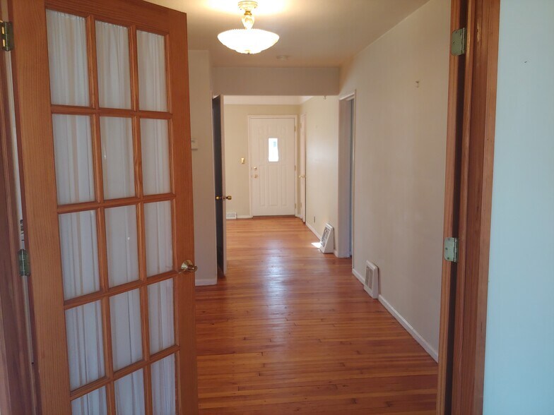 Dining room viewed from the sunroom, with the front door in the background. - 7415 1st Ave S