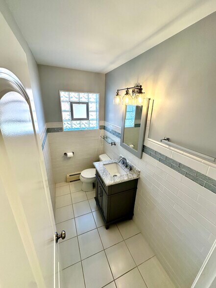 Half bath with new vanity and new tiling. - 671 56th St