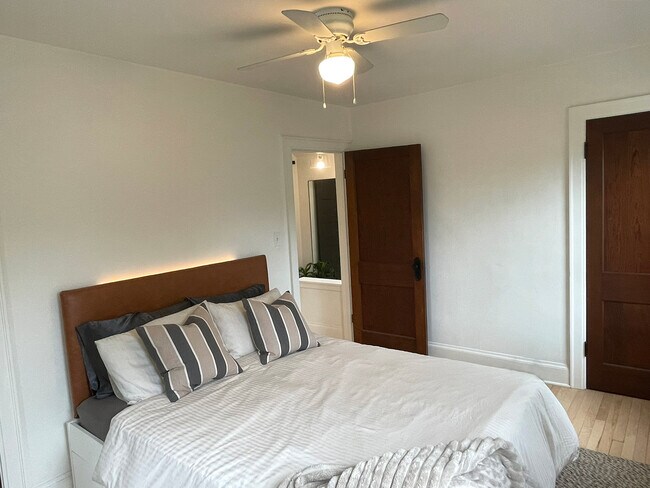 Primary bedroom with two closets and bed with storage. - 3209 Atwood Ave