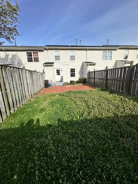 rear fenced yard with brick patio and storage closet off back door - 104 Barrington Ln