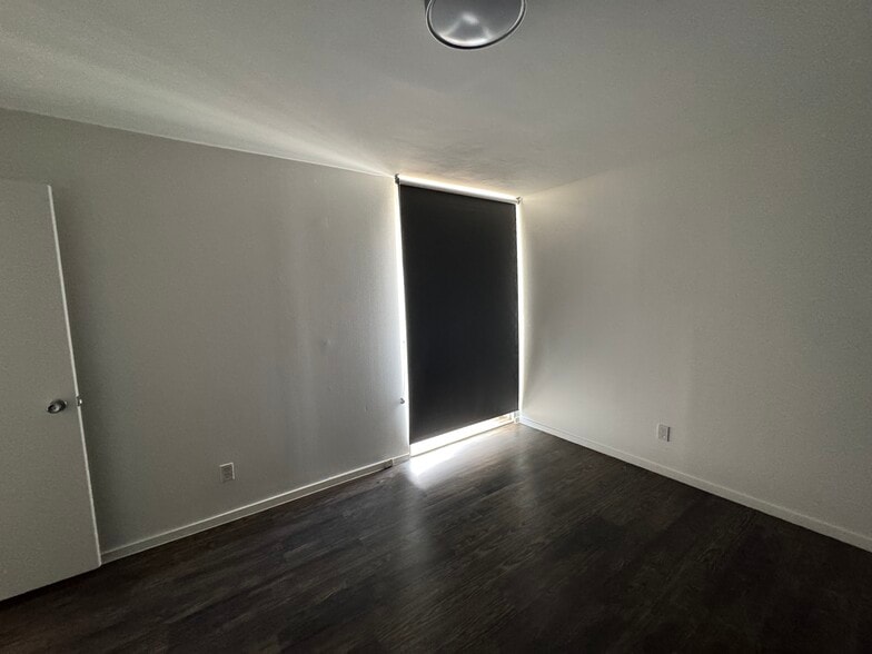 Bedroom features large window with blackout shade - 1502 S Boulder Ave