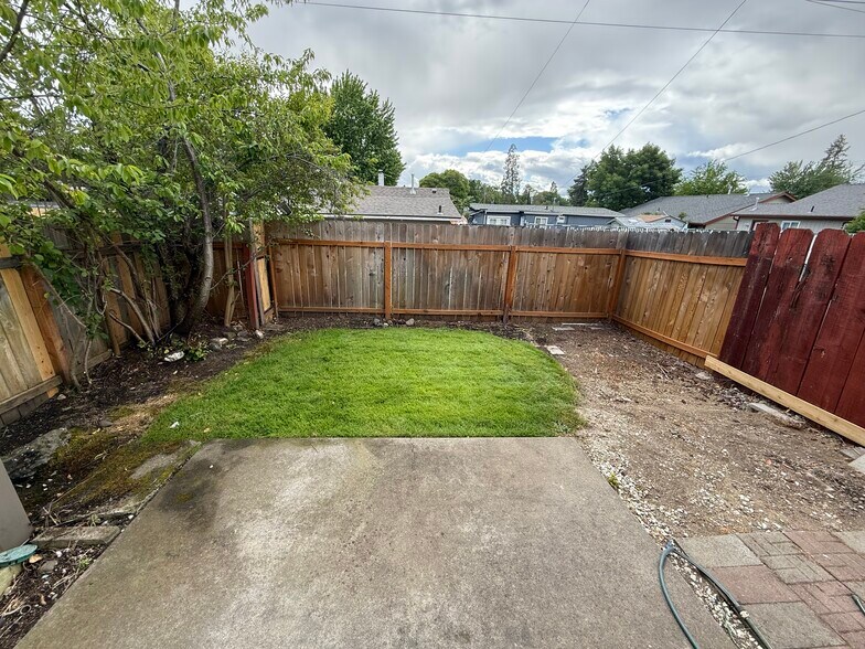 Fenced backyard with grass and paved sitting area - 329 Bessie St