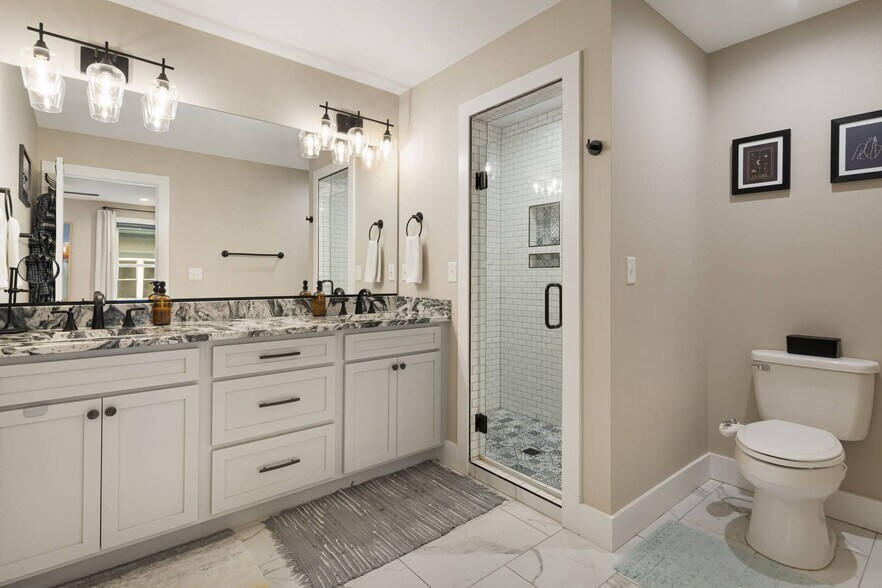 Primary bathroom with walk-in shower and patterned tile. - 33 Rex Dr