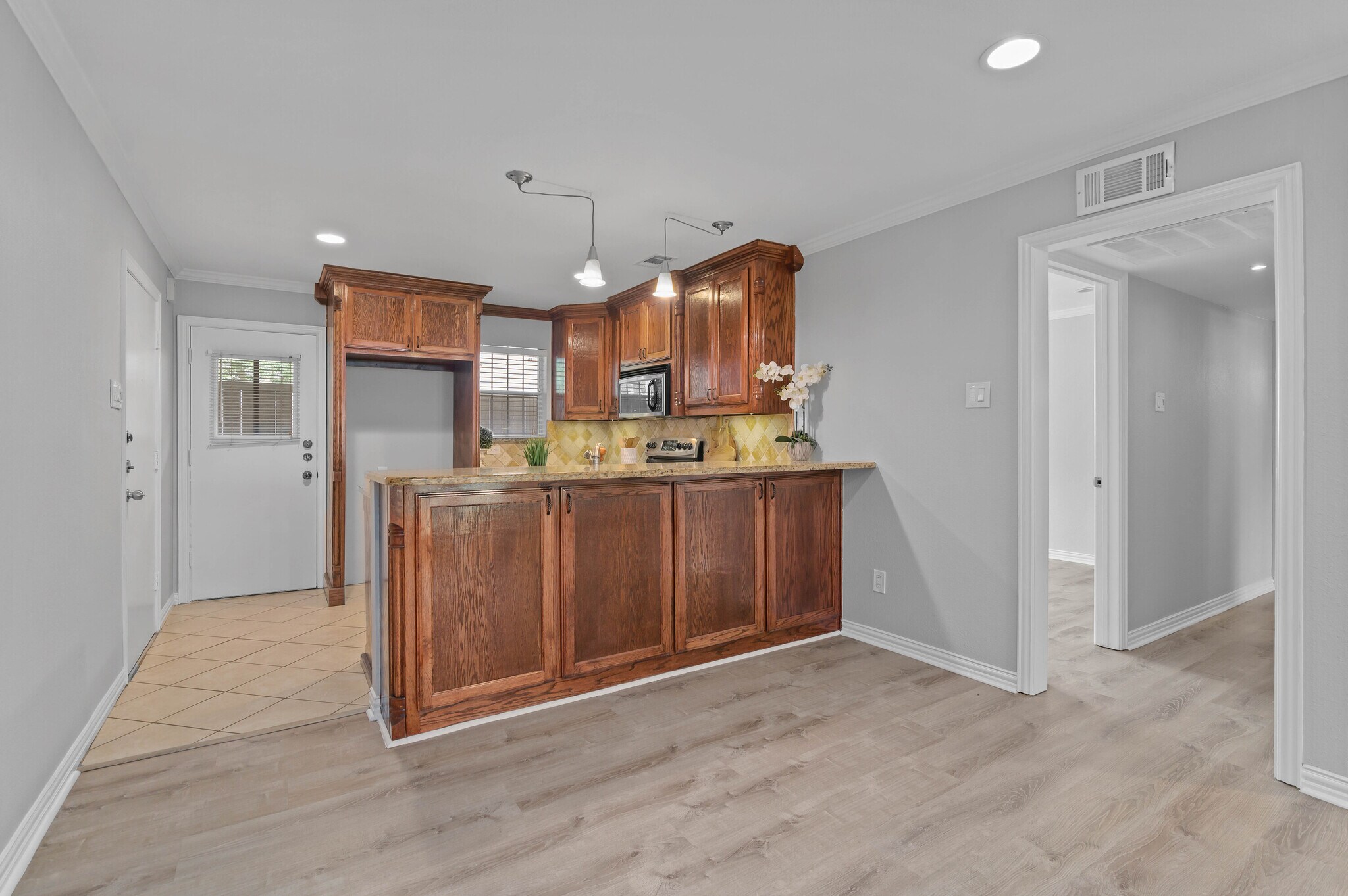 Breakfast Bar & Kitchen view of Patio Door and Hallway to Bedrooms - 5084 Matilda St