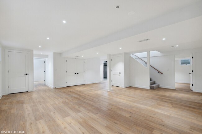 Basement - Rec Room with a view of the exercise room on the far side of stairs + bedroom on left - 1003 Crystal Ct