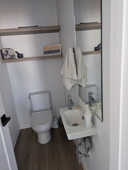 Half bathroom featuring wood finished floors and toilet - 44 W Iko Ave