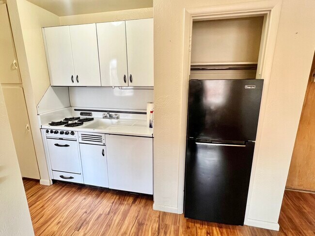 Experience efficient cooking in this stylish kitchen designed for compact spaces. - Hillside Apartments