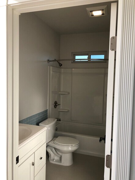 Bathroom with full shower and tub, vanity with sink and storage. - 4470 Swift Ave