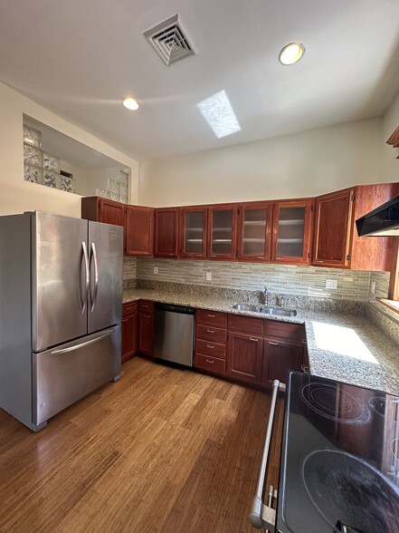 Natural wood cabinetry with glass doors for easy viewing of plates and stemware - 2329 W Grace St