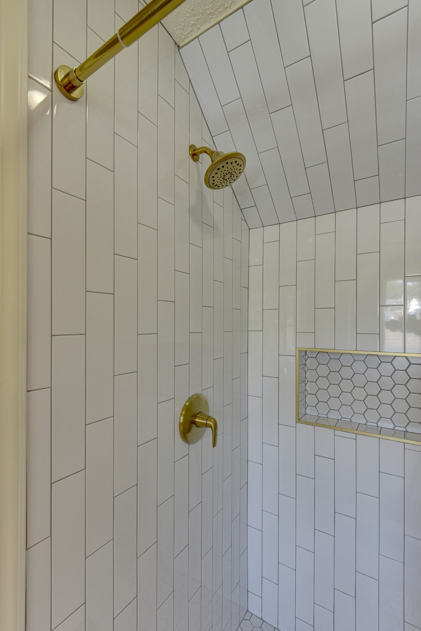 Subway tile shower with soap niche and gold fixtures. - 705 N 75th St