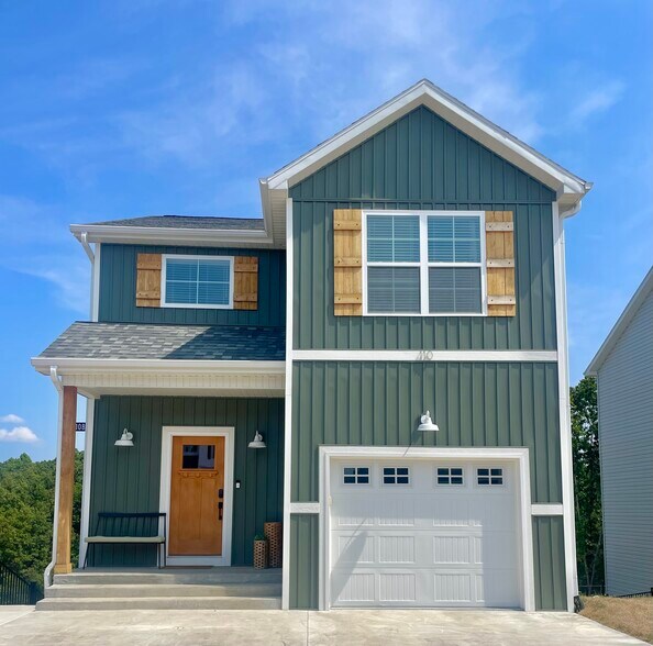 Exterior feat. modern siding, driveway, mailbox, and attached garage. - 110 Sierra Cir