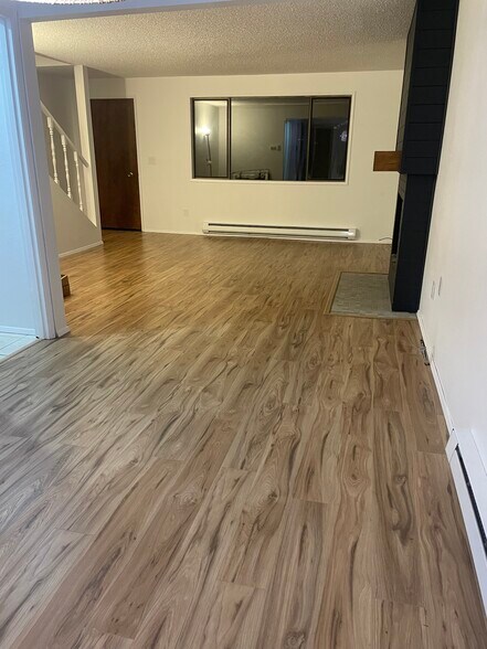New luxury vinyl plank flooring in downstairs. Wood burning fireplace in living room. - 1717 150th Ave SE