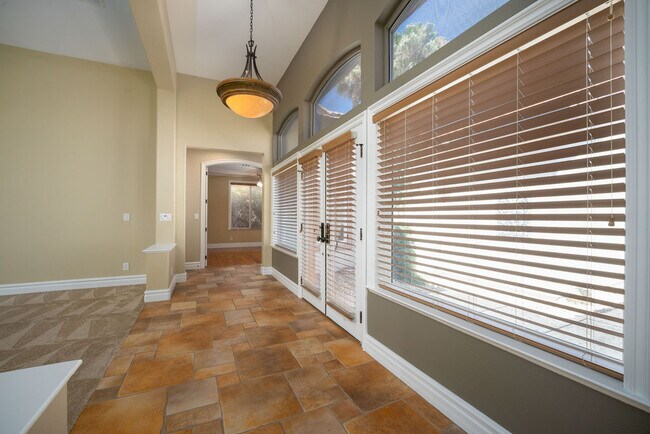 Living room and family room separated by cozy 2-way fireplace with a wet bar - 2850 Bronzino Ct