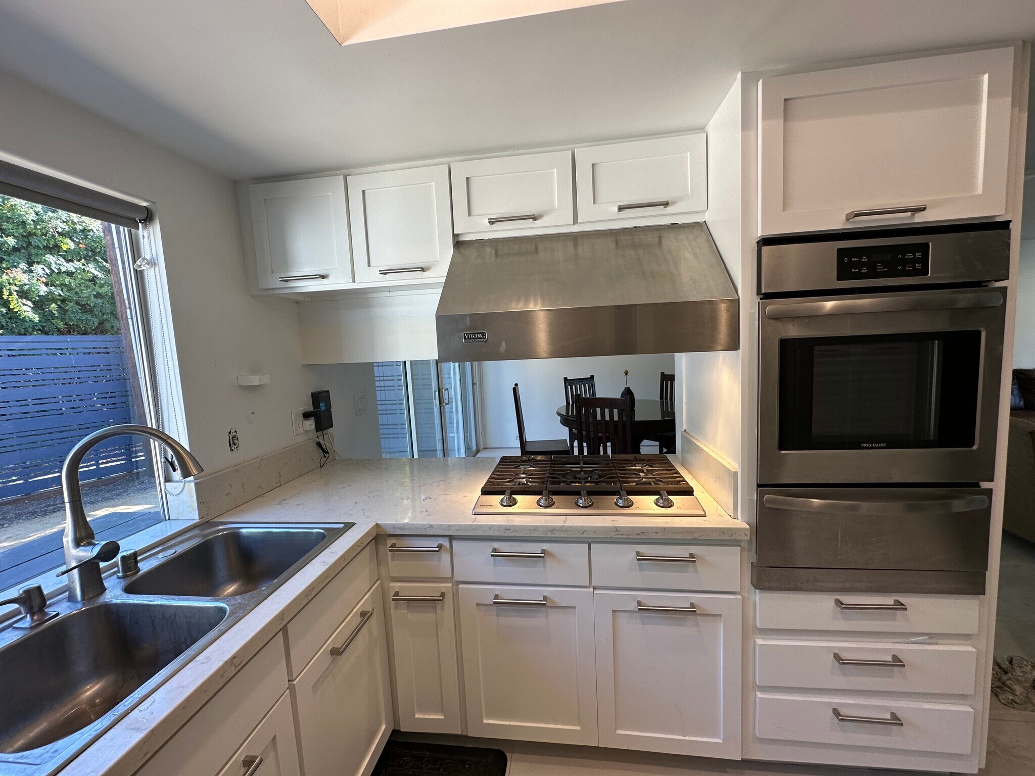 The updated kitchen features crisp white shaker cabinetry, quartz counters, & stainless applicances - 5214 Dawes Ave