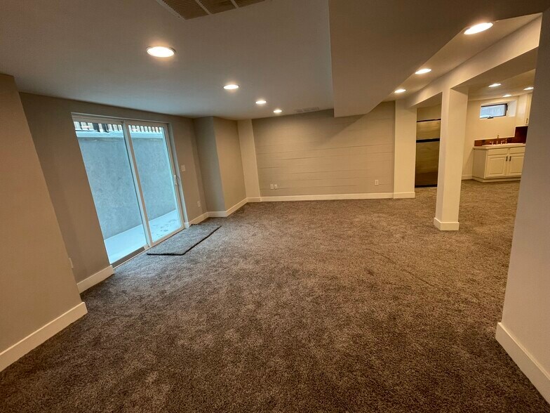 Basement primary bedroom with sliding door to private patio and cool shiplap wall - 508 Daly Ave