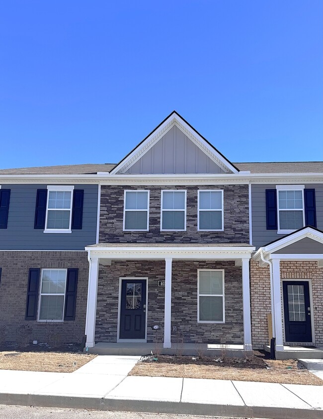 This stone front two-story townhome is 1.5 years old. It is within one block of the community pool. - 403 Augustine Dr