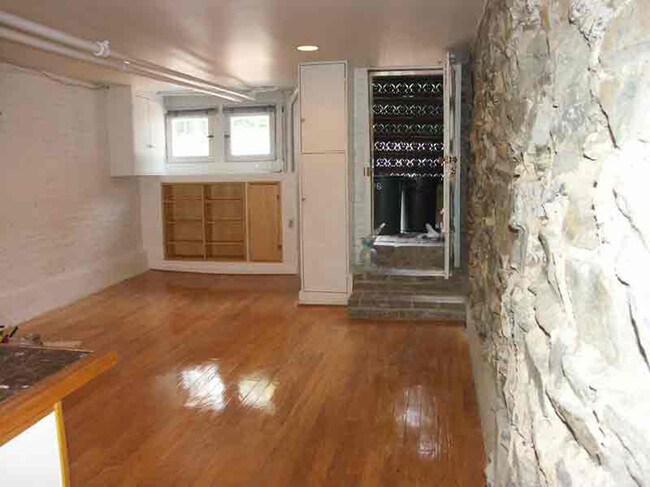 View of living room area without furniture, looking toward the front door of the apartment - 3118 Dumbarton St NW