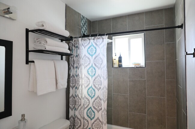 Towel rack with ample in-bathroom storage. More room for towels in the hall closet too! - 8612 Echo St
