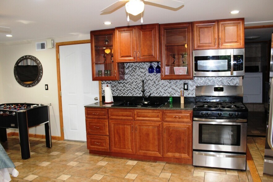 Tiled backsplash, stainless steel gas range and microwave - 102 Holiday Ln
