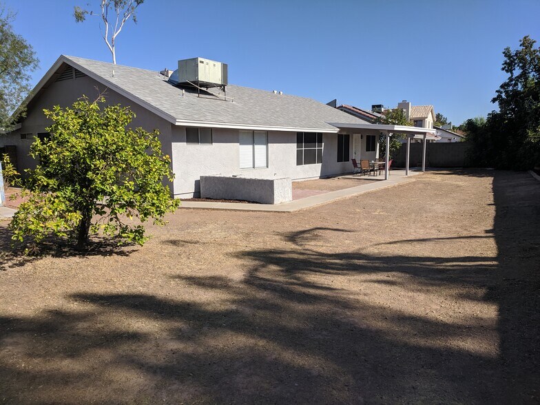 Back of home, facing west. AC unit recently serviced and in great condition. Master bdrm window and bath window in picture. - 14101 N 78th Dr