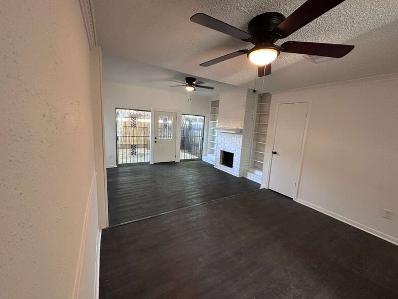 Spacious open-concept living and dining area with modern ceiling fans and laminate flooring - 7700 Creekbend Dr