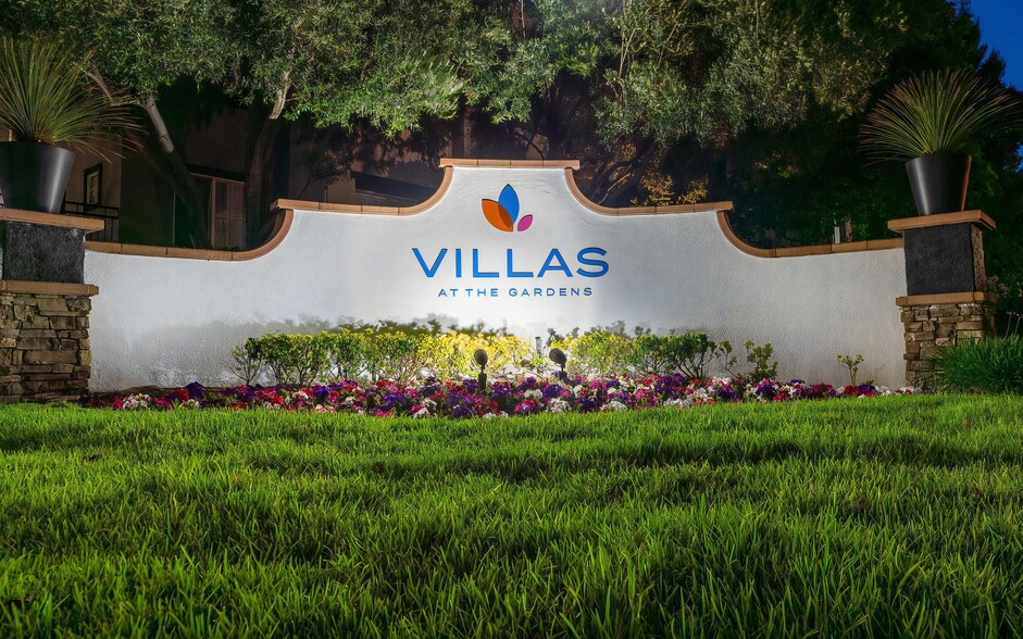 Villas at the Gardens Illuminated Entry Sign with Lush Lawn and Colorful Flowers - Villas at the Gardens