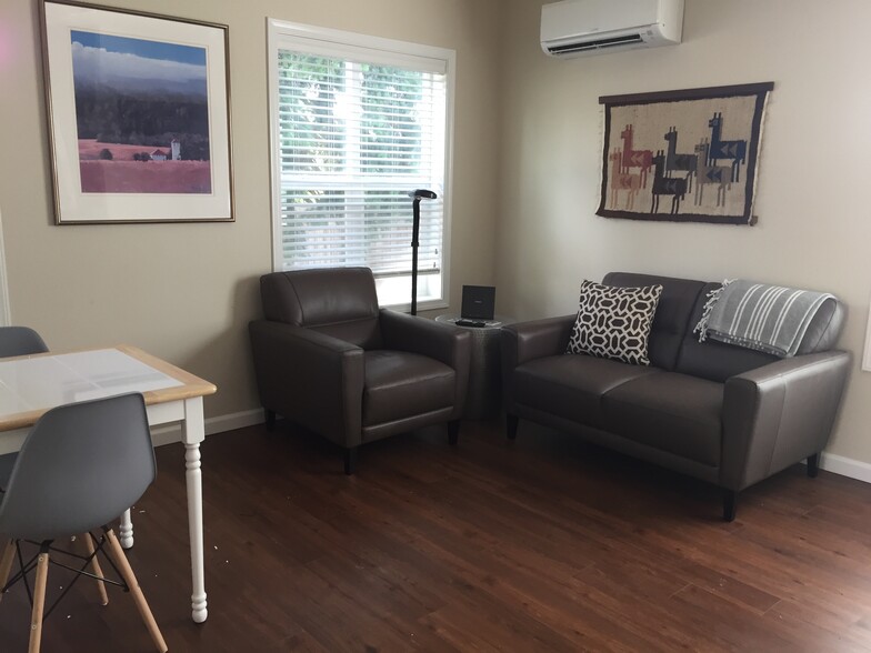 Living room with leather furniture. Dining table next to kitchen pass-through. - 123 Lake Louise Dr SW