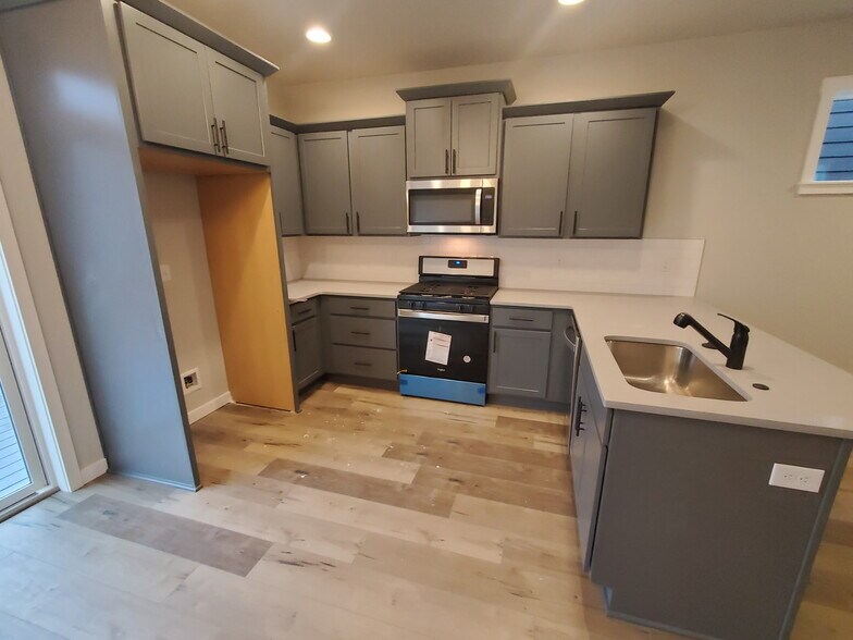 Kitchen, there is a stainless steel refrigerator/freezer in the space it’s just not shown - 161 E Wayno Way