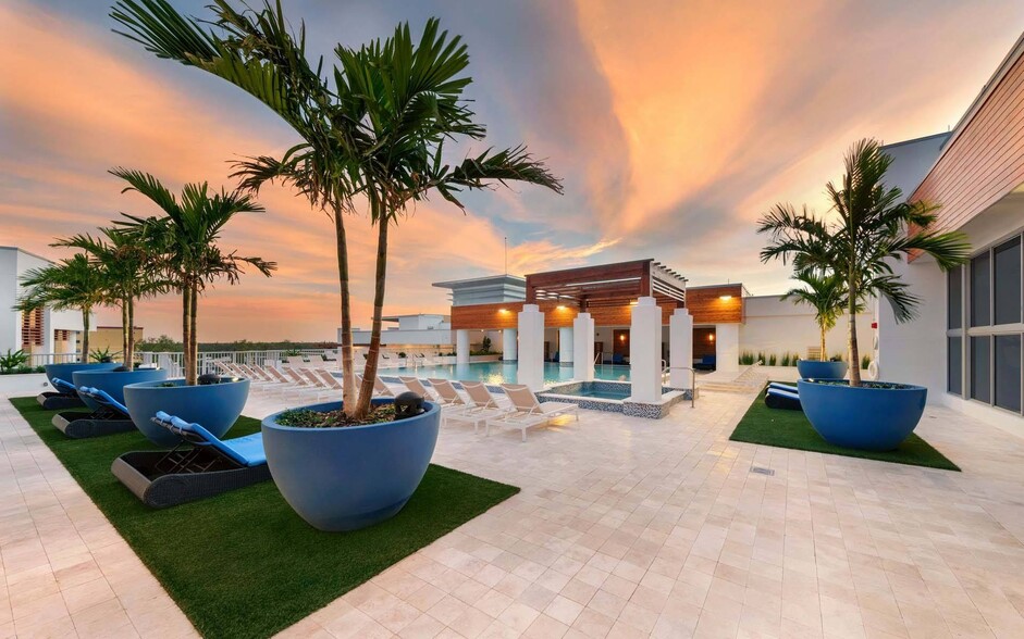 Take in the sunset from the pool, where calm waters and golden skies help you unwind. - Windsor Central Arts
