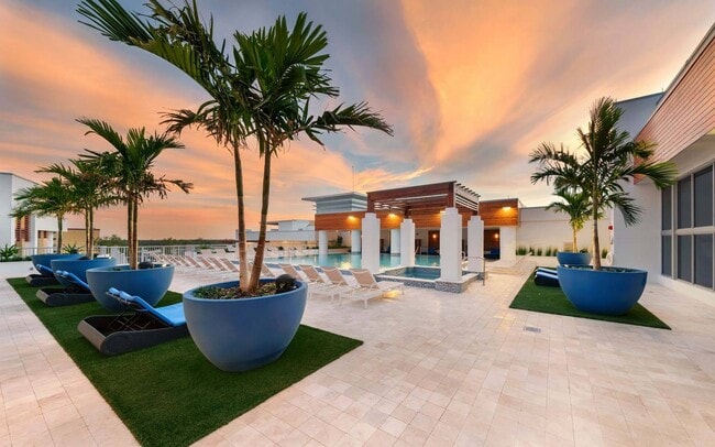 Take in the sunset from the pool, where calm waters and golden skies help you unwind. - Windsor Central Arts