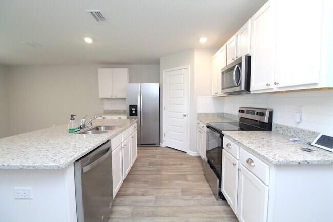 Building Photo - Coming Available Soon – 4BR/2BA Brick Home with Open Floor Plan, Solar Panels & 2-Car Garage in L...