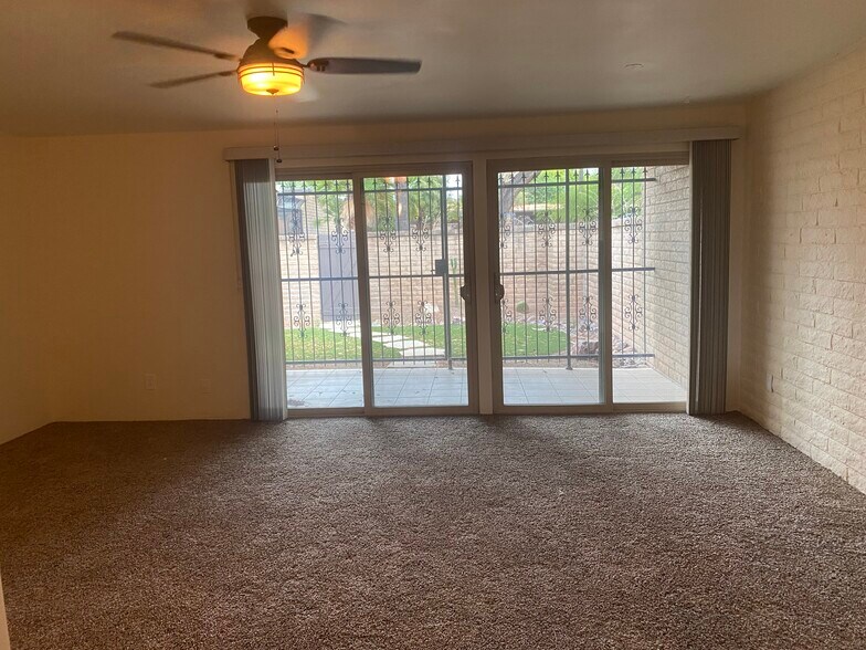 living room with 2 sliders that go out to a covered porch that goes out to a gated yard - 7856 E Linden Pl